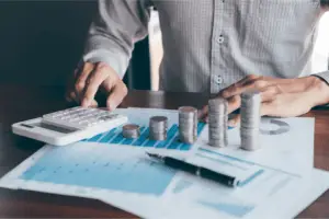 A financial analyst using calculator and counting coins